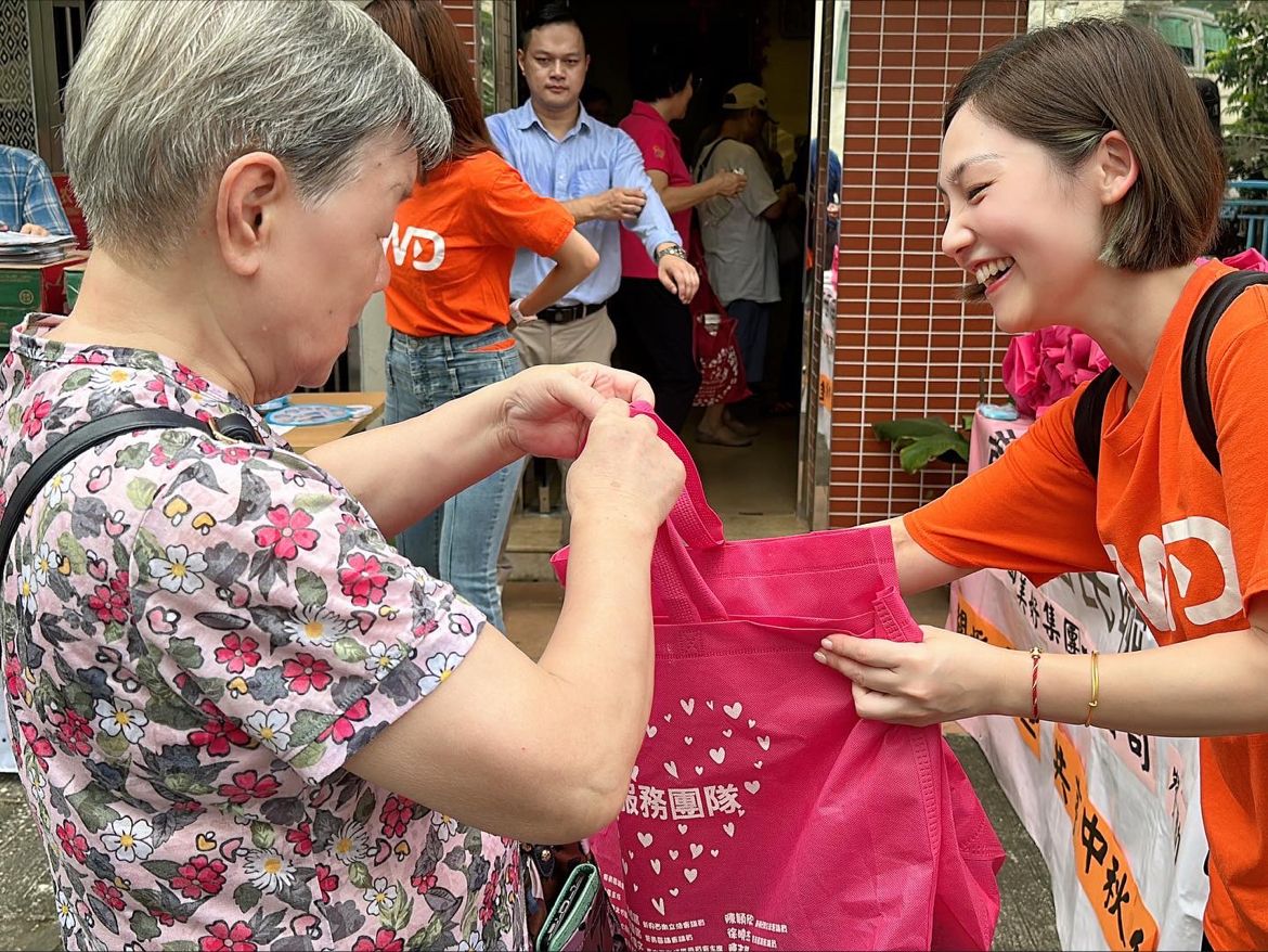 Jessie Chiu handing a community gift bag to an elderly resident